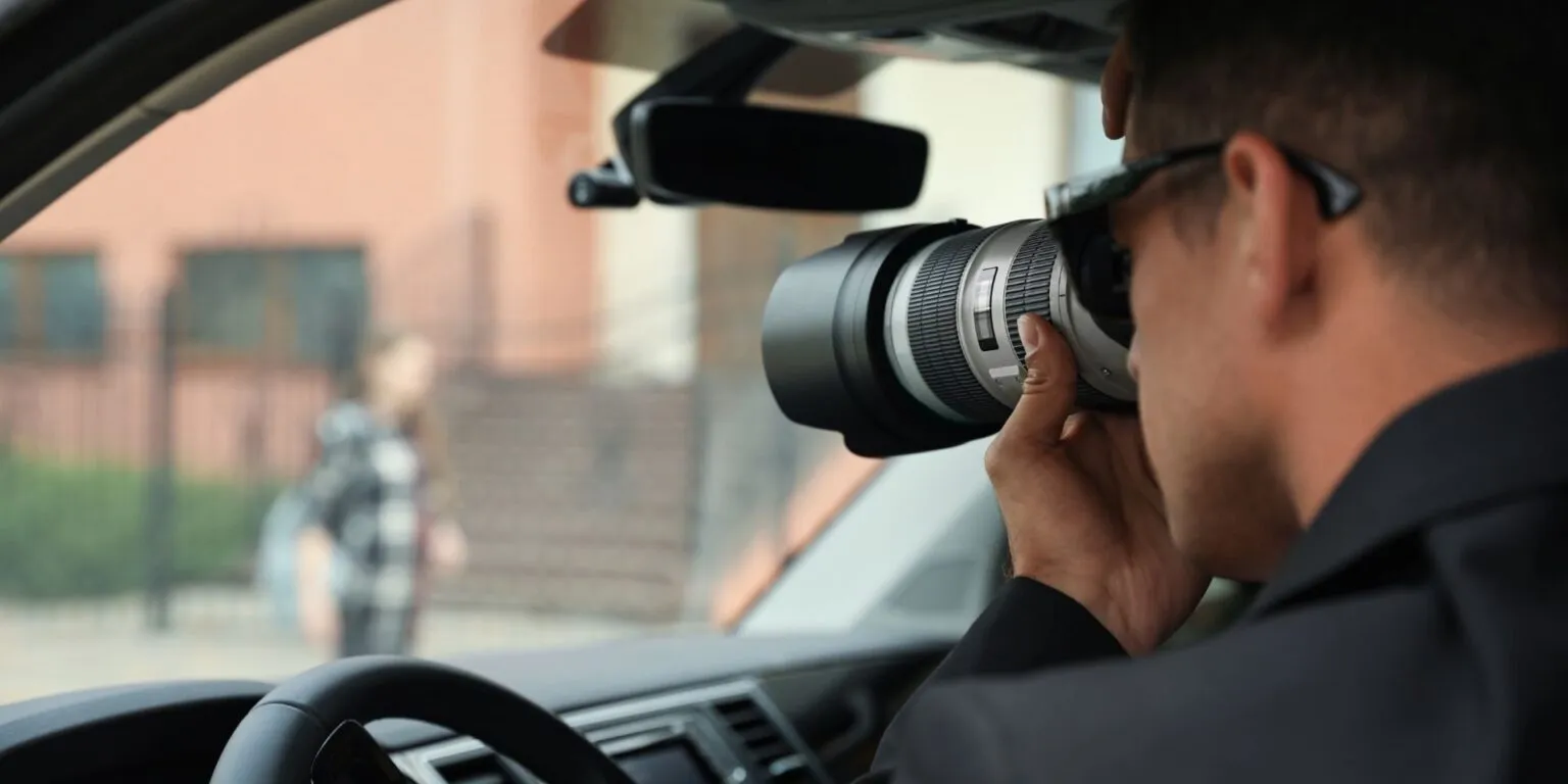 Licensed investigator conducting covert surveillance from vehicle